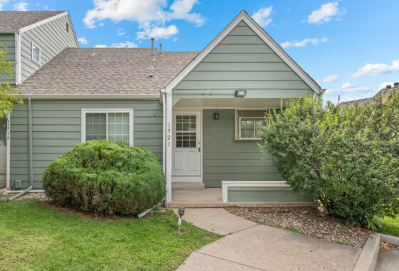 Green townhouse entrance with shrubs and walkway